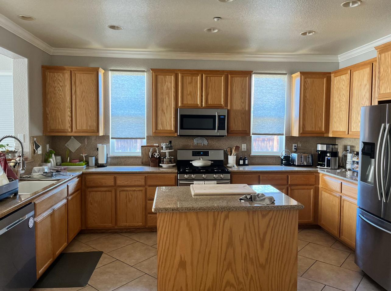 A kitchen with cabinets refinished in white Sayerlack — a Bronco Painting transformation