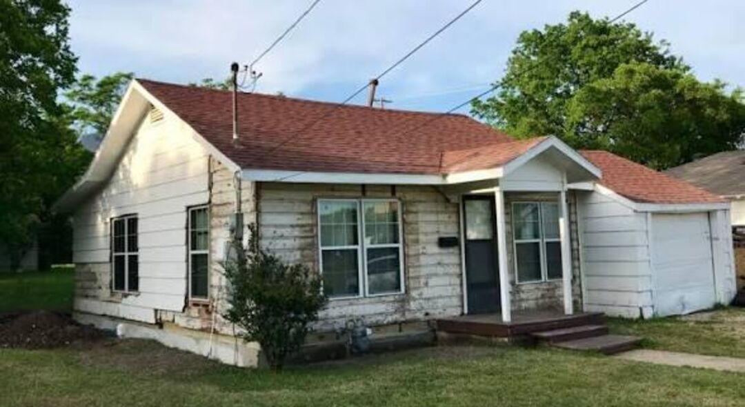 Small house with peeling white paint before repaint